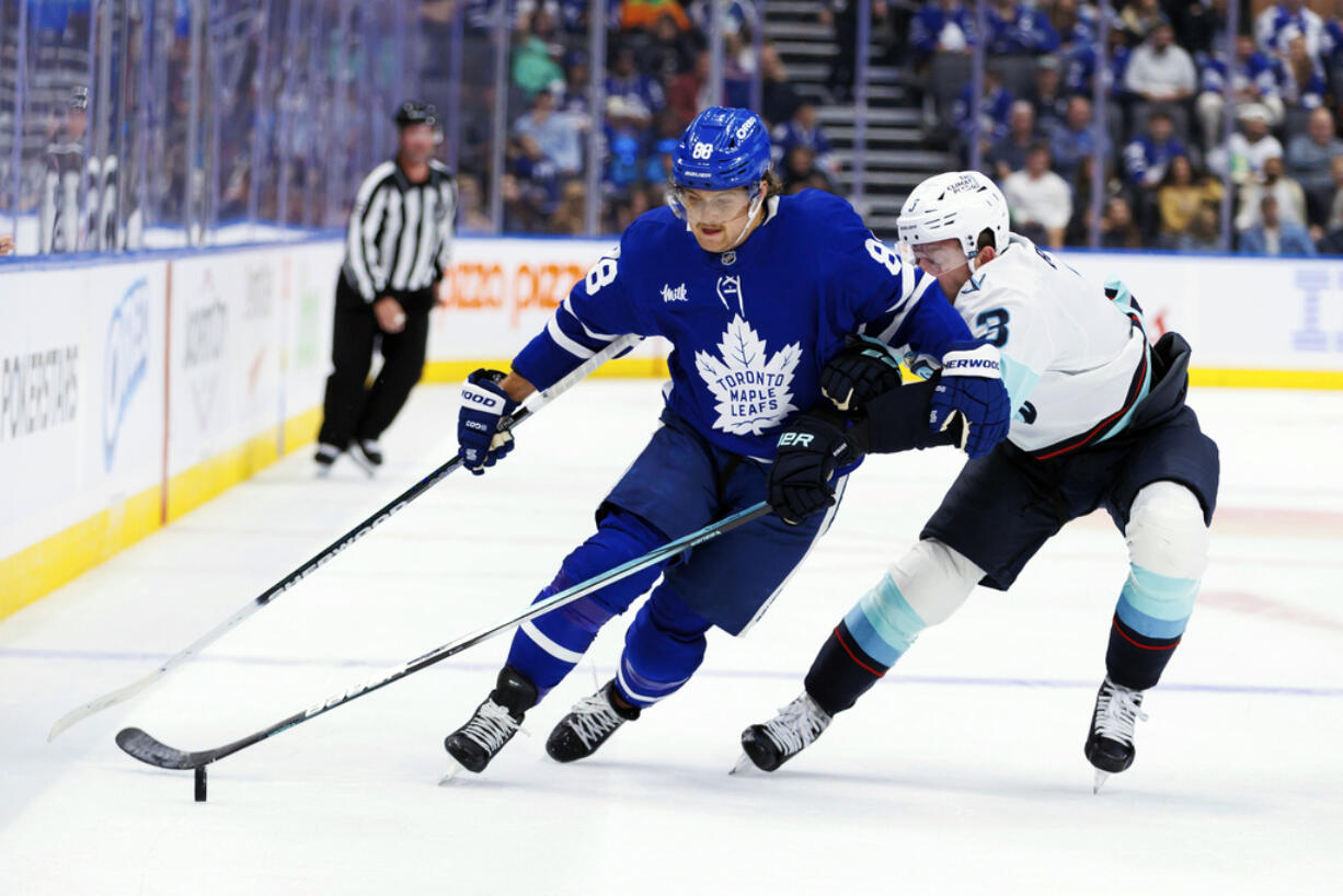 Toronto Maple Leafs' William Nylander (88) and Seattle Kraken's Will Borgen (3) battle for the puck during the second period of an NHL hockey game in Toronto, Thursday, Oct, 31, 2024.