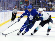 Toronto Maple Leafs' William Nylander (88) and Seattle Kraken's Will Borgen (3) battle for the puck during the second period of an NHL hockey game in Toronto, Thursday, Oct, 31, 2024.