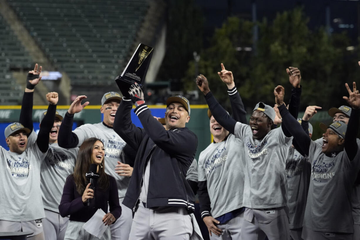 New York Yankees&#039; Giancarlo Stanton holds up the MVP trophy after Game 5 of the baseball AL Championship Series Sunday, Oct. 20, 2024, in Cleveland. The Yankees won 5-2 to advance to the World Series. (AP Photo/Godofredo A.