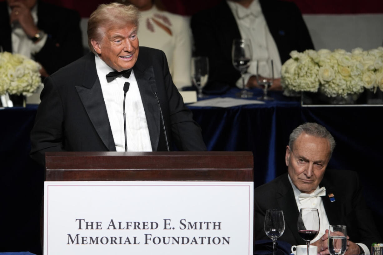 Republican presidential nominee former President Donald Trump speaks as Senate Majority Leader Chuck Schumer of N.Y., listens at the 79th annual Alfred E. Smith Memorial Foundation Dinner, Thursday, Oct. 17, 2024, in New York.