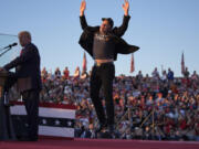 Elon Musk jumps on the stage as Republican presidential nominee former President Donald Trump speaks at a campaign rally at the Butler Farm Show, Saturday, Oct. 5, 2024, in Butler, Pa.