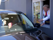 Republican presidential nominee former President Donald Trump hands an order to a customer at a drive-thru window during a campaign stop at a McDonald&#039;s, Sunday, Oct. 20, 2024, in Feasterville-Trevose, Pa.