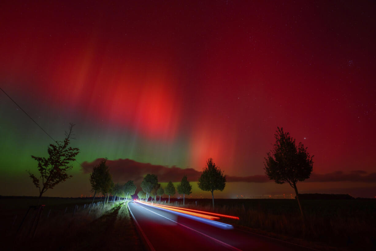 An aurora borealis, also known as the northern lights, glows in the night sky above a road in Lietzen, eastern Germany.