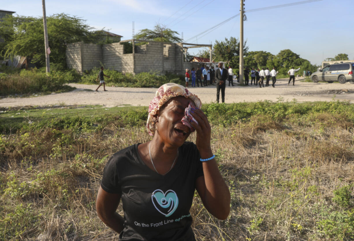 A neighbor cries during the funeral of Jean Louis Jeune Gracien, who was killed during an attack by armed gangs Tuesday in Pont-Sonde, Haiti.