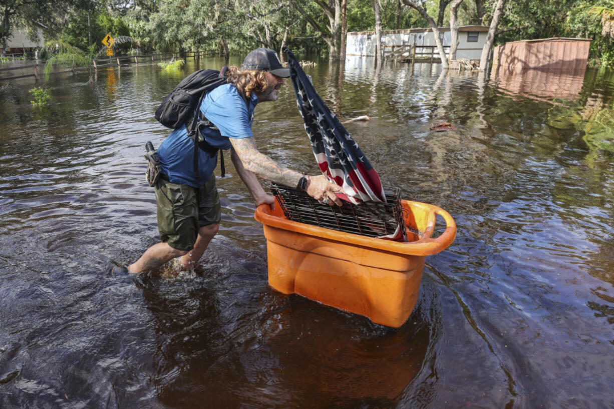 A man who identified himself as Jesse walks out through floodwaters of the Anclote River after Hurricane Milton hit the region, Thursday, Oct. 10, 2024, in New Port Richey, Fla.