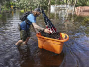 A man who identified himself as Jesse walks out through floodwaters of the Anclote River after Hurricane Milton hit the region, Thursday, Oct. 10, 2024, in New Port Richey, Fla.