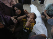 Mourners attend the funeral of Palestinians killed in the Israeli bombardment of the Gaza Strip outside the hospital morgue in Deir al-Balah on Wednesday, Oct. 9, 2024.