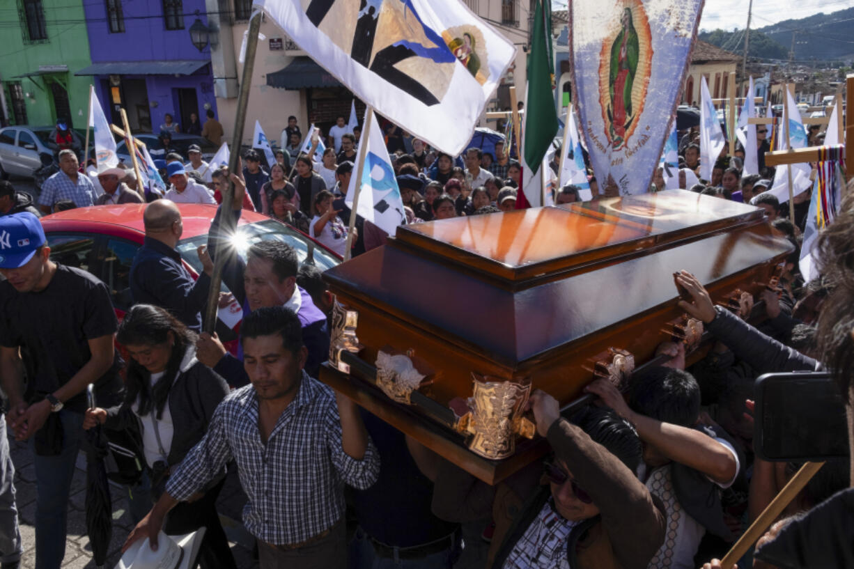 People carry the coffin of Catholic priest Marcelo Perez, who was killed in San Cristobal de las Casas, Chiapas state, Mexico, Sunday, Oct. 20, 2024.