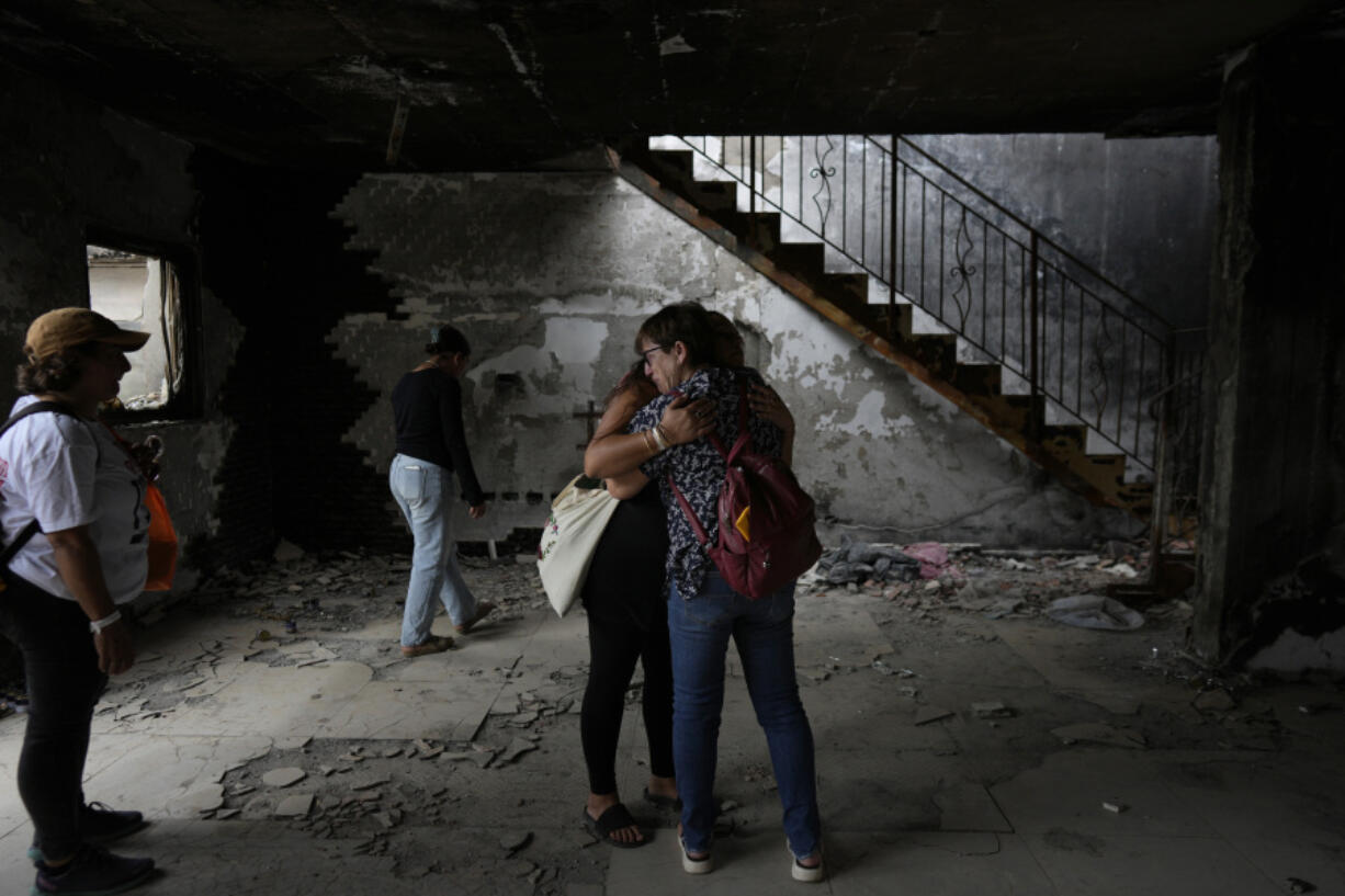 People hug at the house of Maayan and Yuval Bar killed by Hamas, as Israel marks the one-year anniversary of the Hamas attack on Israel, at the Kibbutz Be&rsquo;eri, an Israeli communal farm on the Gaza border, on Monday, Oct. 7, 2024.