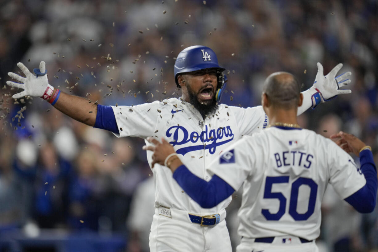 Los Angeles Dodgers&#039; Teoscar Hern&aacute;ndez, left, gets sunflower seeds to the face to celebrate his solo home run as Mookie Betts (50) looks on during the seventh inning in Game 5 of a baseball NL Division Series against the San Diego Padres, Friday, Oct. 11, 2024, in Los Angeles.