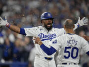 Los Angeles Dodgers&#039; Teoscar Hern&aacute;ndez, left, gets sunflower seeds to the face to celebrate his solo home run as Mookie Betts (50) looks on during the seventh inning in Game 5 of a baseball NL Division Series against the San Diego Padres, Friday, Oct. 11, 2024, in Los Angeles.