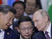 Chinese President Xi Jinping, left, and Russian President Vladimir Putin, right, speak during Outreach/BRICS Plus format session at BRICS Summit in Kazan, Russia, Thursday, Oct. 24, 2024.