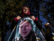 Svetlana holds a flag with a photo of her son Andrii Savchuk, a Ukrainian officer of the 36th marine brigade, during a gathering in support of soldiers who defended Mariupol and are still in Russian captivity after two and half years, in Kyiv, Ukraine, Wednesday, Oct. 9, 2024.