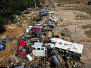 A man stands next to flooded cars piled up in Valencia, Spain, Thursday, Oct. 31, 2024.