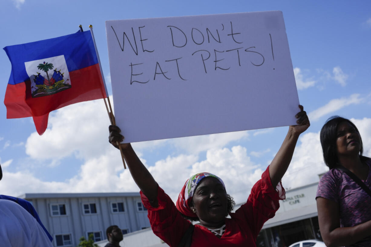 Wilda Brooks of West Palm Beach, Fla., holds up a sign reading &ldquo;We don&rsquo;t eat pets,&rdquo; during a rally by members of South Florida&rsquo;s Haitian-American community to condemn hate speech and misinformation about Haitian immigrants, Sunday, Sept. 22, 2024, in North Miami, Fla.