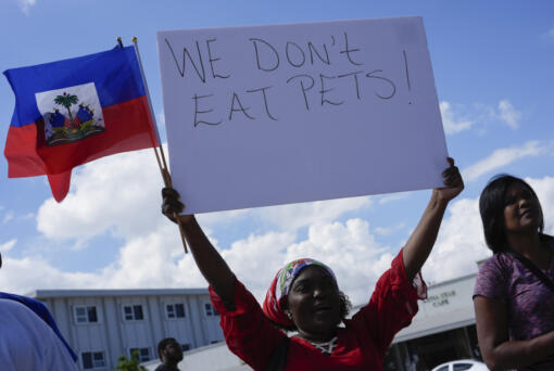 Wilda Brooks of West Palm Beach, Fla., holds up a sign reading &ldquo;We don&rsquo;t eat pets,&rdquo; during a rally by members of South Florida&rsquo;s Haitian-American community to condemn hate speech and misinformation about Haitian immigrants, Sunday, Sept. 22, 2024, in North Miami, Fla.