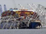 The cargo ship Dali is stuck under part of the structure of the Francis Scott Key Bridge after the ship hit the bridge, Tuesday, March 26, 2024, as seen from Pasadena, Md.