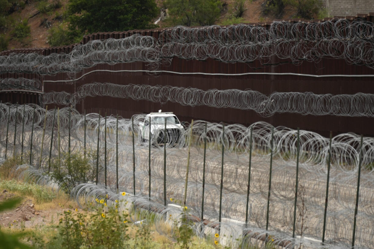 FILE - A vehicle drives along the U.S. side of the US-Mexico border wall in Nogales, Ariz., June 25, 2024. The Biden administration is making asylum restrictions at the southern border even tougher. The changes come in the middle of an election campaign where border security is a key concern for voters, and the administration is increasingly eager to show voters it&rsquo;s taking a hard stance. (AP Photo/Jae C.