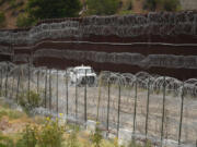 FILE - A vehicle drives along the U.S. side of the US-Mexico border wall in Nogales, Ariz., June 25, 2024. The Biden administration is making asylum restrictions at the southern border even tougher. The changes come in the middle of an election campaign where border security is a key concern for voters, and the administration is increasingly eager to show voters it&rsquo;s taking a hard stance. (AP Photo/Jae C.