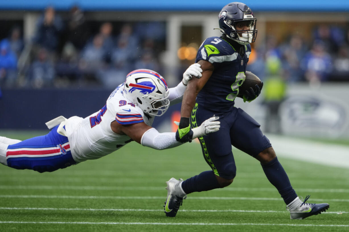 Seattle Seahawks running back Kenneth Walker III (9) runs the ball against Buffalo Bills defensive end Dawuane Smoot (94) during the first half of an NFL football game, Sunday, Oct. 27, 2024, in Seattle.