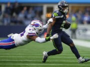 Seattle Seahawks running back Kenneth Walker III (9) runs the ball against Buffalo Bills defensive end Dawuane Smoot (94) during the first half of an NFL football game, Sunday, Oct. 27, 2024, in Seattle.