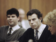 FILE - Lyle, left, and Erik Menendez sit with defense attorney Leslie Abramson, right, in Beverly Hills Municipal Court during a hearing, Nov. 26, 1990.