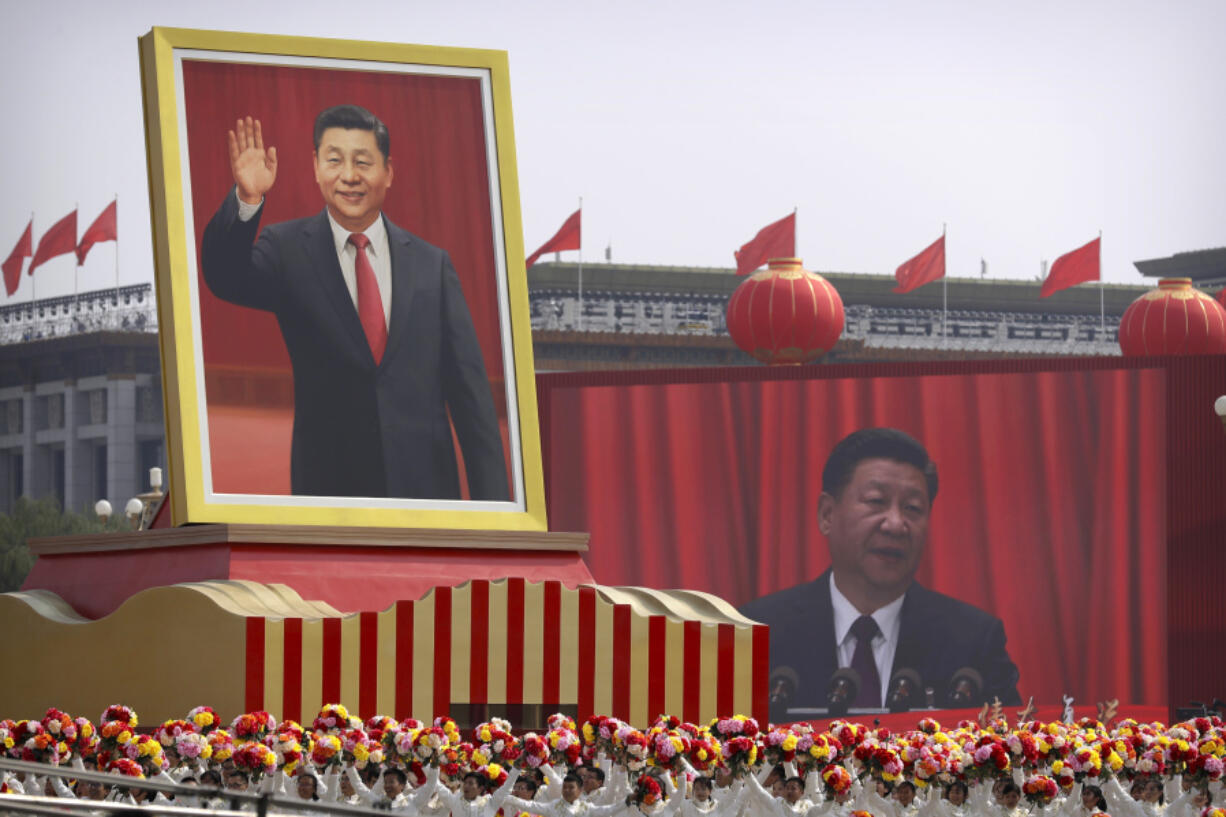 FILE - Participants cheer beneath a large portrait of Chinese President Xi Jinping during a parade to commemorate the 70th anniversary of the founding of Communist China in Beijing, Tuesday, Oct. 1, 2019.