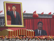 FILE - Participants cheer beneath a large portrait of Chinese President Xi Jinping during a parade to commemorate the 70th anniversary of the founding of Communist China in Beijing, Tuesday, Oct. 1, 2019.