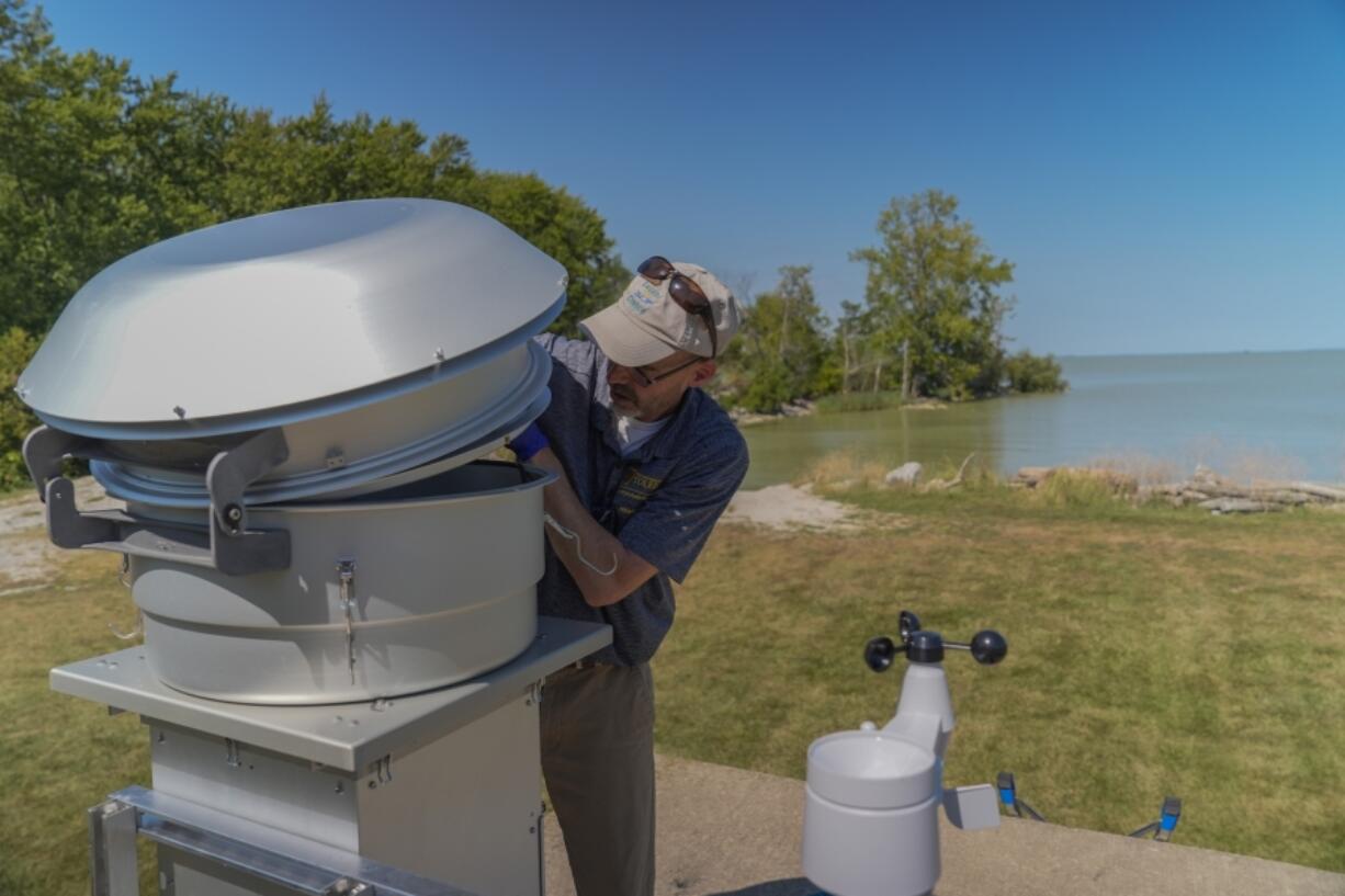 David Kennedy, an associate professor of medicine at the University of Toledo, replaces an air filter inside of a monitoring station near Lake Erie, Thursday, Sept. 5, 2024, in Oregon, Ohio. (AP Photo/Joshua A.