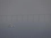 FILE - A boat navigates the Negro River amid smoke from wildfires in Manaus, Amazonas state, Brazil, Aug. 27, 2024.