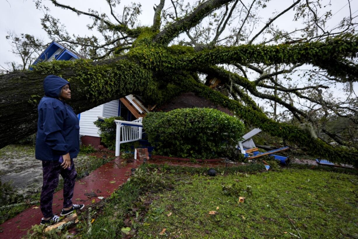 FILE - Rhonda Bell looks on after an Oak tree landed on her 100-year-old home after Hurricane Helene moved through, Friday, Sept. 27, 2024, in Valdosta, Ga.