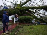 FILE - Rhonda Bell looks on after an Oak tree landed on her 100-year-old home after Hurricane Helene moved through, Friday, Sept. 27, 2024, in Valdosta, Ga.