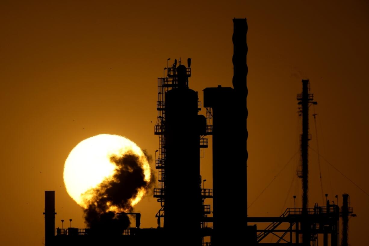 The CHS oil refinery is silhouetted against the setting sun Sept. 28 in McPherson, Kan.