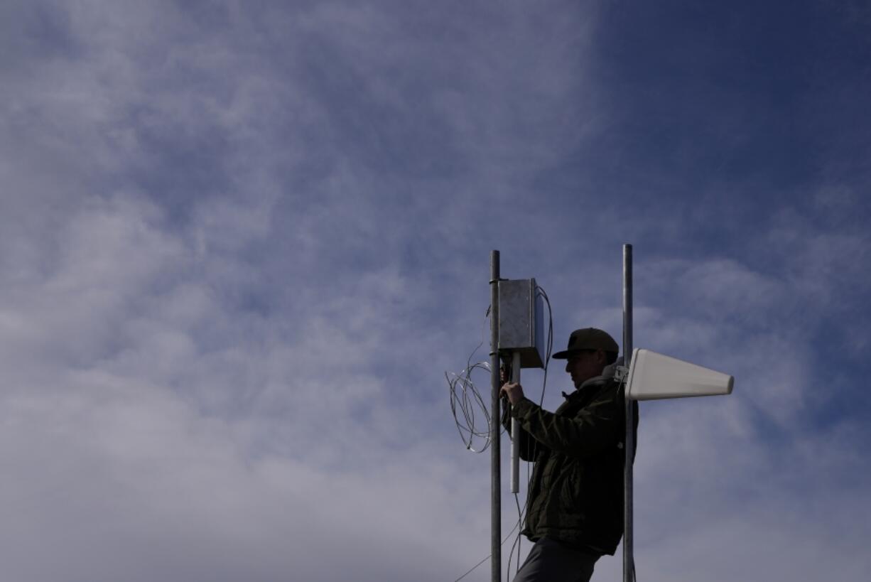 FILE - Carver Cammans installs cloud seeding equipment, Dec. 3, 2022, in Lyons, Colo.