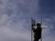 FILE - Carver Cammans installs cloud seeding equipment, Dec. 3, 2022, in Lyons, Colo.