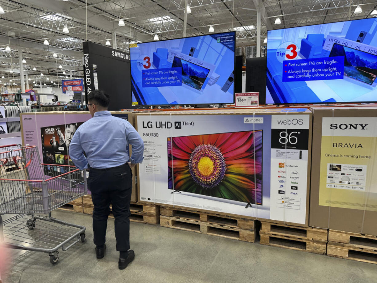 FILE - A shopper considers large-screen televisions on display in a Costco warehouse Oct. 3, 2024, in Timnath, Colo.