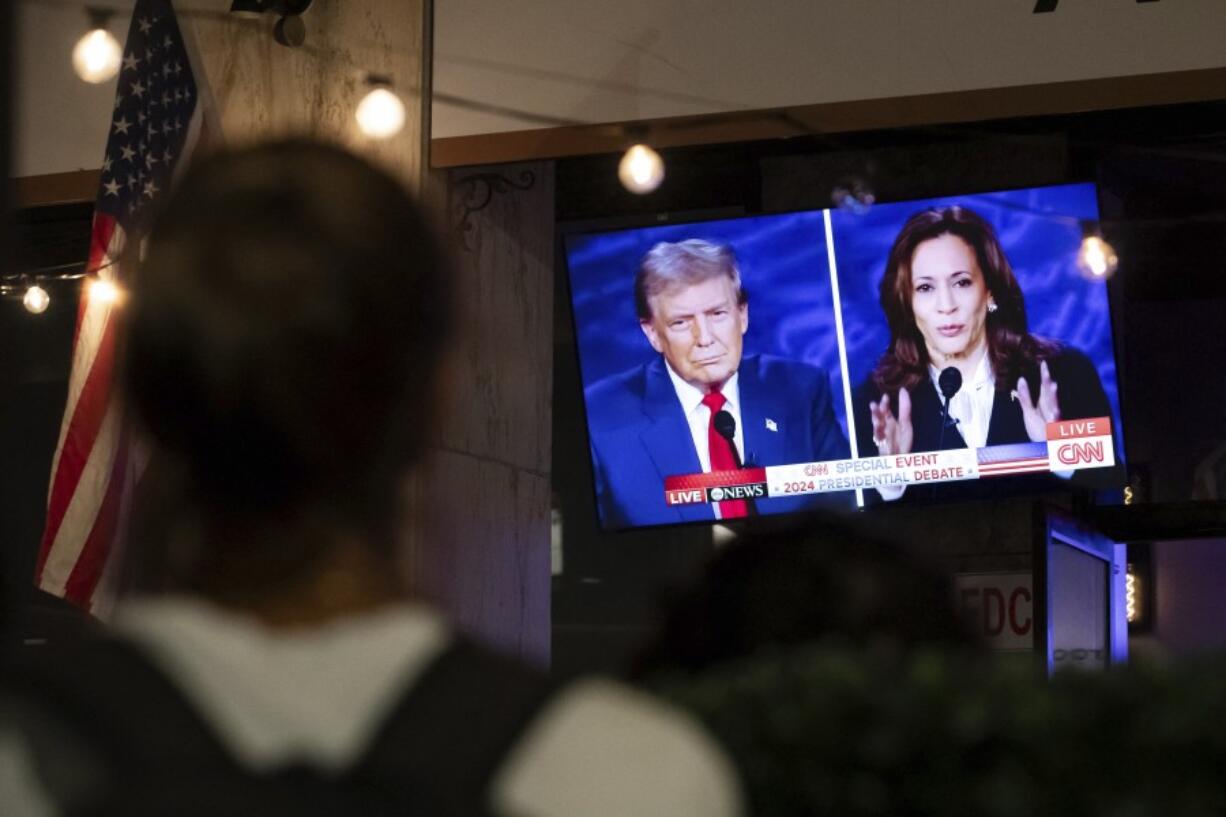 In this image released on Friday, October, 18, 2024,  a person stops to watch a screen displaying the US Presidential debate between Vice President and Democratic presidential candidate Kamala Harris and former US president and Republican presidential candidate Donald Trump in Washington, DC.  HANDOUT IMAGE - Please see Special Instructions. Press release and media available to download at www.apmultimedianewsroom.com/newsaktuell.