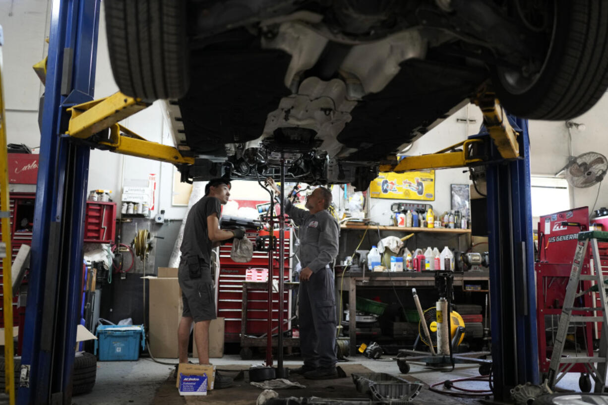 FILE - Auto mechanics work on a vehicle at the Express Auto Service Inc., in Chicago, Sept. 19, 2024. (AP Photo/Nam Y.