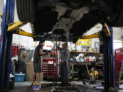 FILE - Auto mechanics work on a vehicle at the Express Auto Service Inc., in Chicago, Sept. 19, 2024. (AP Photo/Nam Y.