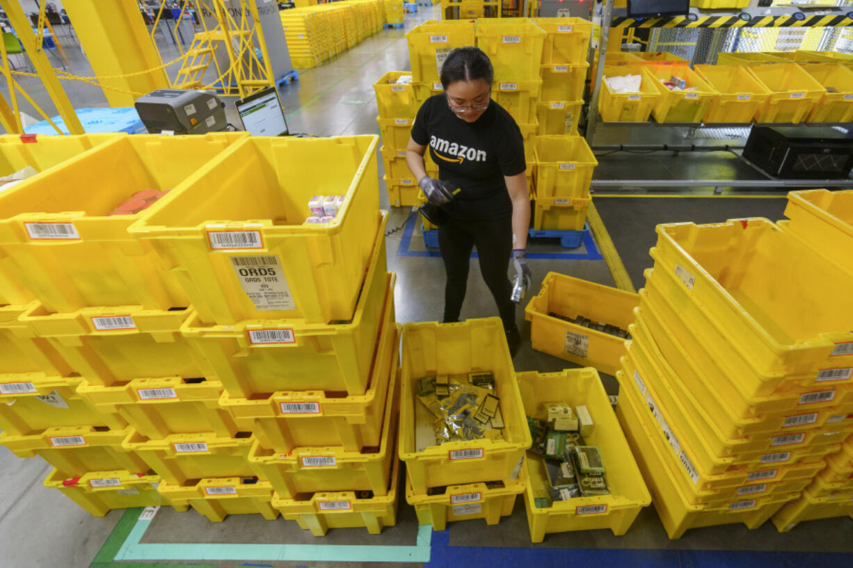 FILE - An employee scans incoming items at a receiving station at the Amazon OXR1 fulfillment center in Oxnard, Calif., on Aug. 21, 2024.