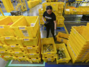 FILE - An employee scans incoming items at a receiving station at the Amazon OXR1 fulfillment center in Oxnard, Calif., on Aug. 21, 2024.