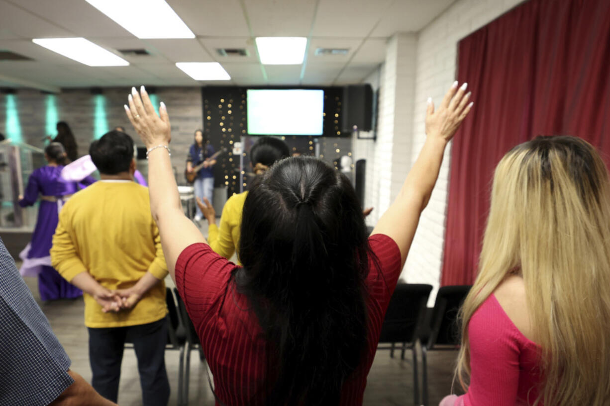 A congregant worships during services at Casa de Adoracion, Sunday, Oct. 27, 2024 in Phoenix.