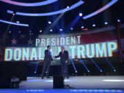 FILE - Former President Donald Trump, right, shakes hands with Turning Point CEO Charlie Kirk before speaking during the Turning Point USA Student Action Summit, Saturday, July 23, 2022, in Tampa, Fla. (AP Photo/Phelan M.