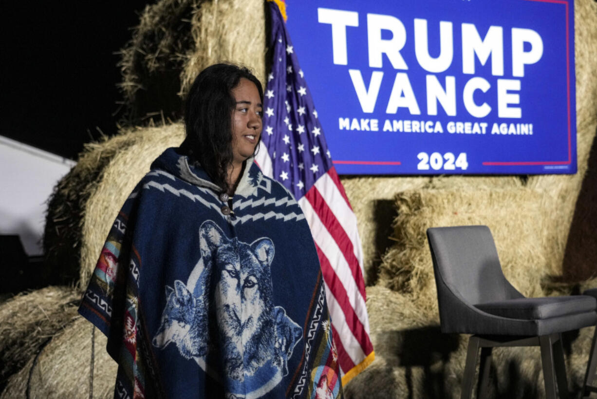 A Native American woman walks by the stage during a campaign event in support of Republican presidential nominee former President Donald Trump, Friday, Oct. 18, 2024, in Red Springs, N.C.