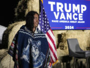 A Native American woman walks by the stage during a campaign event in support of Republican presidential nominee former President Donald Trump, Friday, Oct. 18, 2024, in Red Springs, N.C.