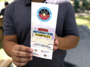 Alexander Castillo-Nunez, a civic engagement coordinator at the Inter Tribal Council of Arizona, Inc., shows a voter information pamphlet at an Arizona Native Vote booth during an Indigenous Peoples&rsquo; Day event, Monday, Oct. 14, 2024, in Phoenix. (AP Photo/Ross D.