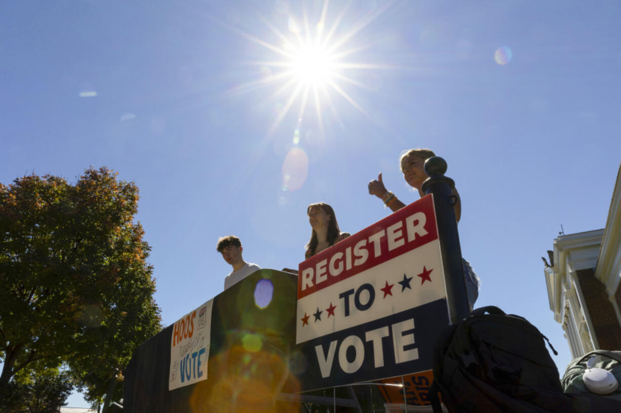 James Galvin, Ella Nelsen and Charlotte Papacosma register students to vote at the University of Virginia in Charlottesville, Va., Friday, Oct. 11, 2024. (AP Photo/Ryan M.