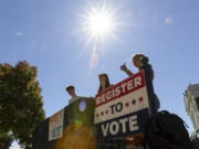 James Galvin, Ella Nelsen and Charlotte Papacosma register students to vote at the University of Virginia in Charlottesville, Va., Friday, Oct. 11, 2024. (AP Photo/Ryan M.