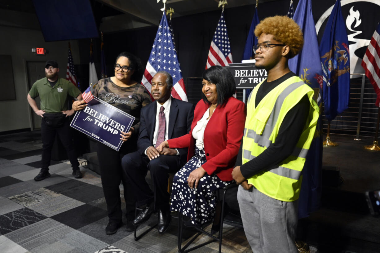 Former housing Secretary Ben Carson, center, and his wife, Candy Carson, right center, pose for a photo with Tiffany King, second from left, and her son Nehemiah King, right, following Carson&rsquo;s address to supporters of former President Donald Trump on Oct. 5 in Livonia, Mich.