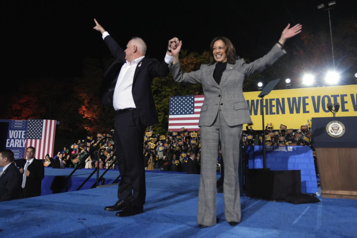 Democratic presidential nominee Vice President Kamala Harris, right, and her running mate Minnesota Gov. Tim Walz depart after speaking during a campaign rally at Burns Park in Ann Arbor, Mich., Monday, Oct. 28, 2024.